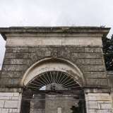 L'accesso � incastonato nella cinta muraria che funge da perimetro del sito. � costituito da un cancello in ferro grigio inglobato in un arco a tutto sesto in pietra: quest'ultimo ha una chiave di volta decorata con un giglio, lo stemma dei Tanzi